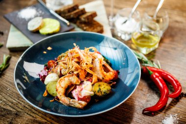 Arjantin kral karidesli sıcak salata. Badem patatesi, mini romaine marulu, havuç, vişneli domates, pesto, siyah kök cipsi, karamelli ceviz, pancar balzamisi. Modern restoranda yemek servisi..