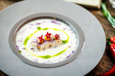 Kudüs enginar-badem kremalı çorba ve deniz tarağı rulosu. Pırasa, badem sütü, sarımsak. Lezzetli, sağlıklı, geleneksel Yahudi yemekleri modern gurme restoranındaki bir masada öğle yemeği için servis ediliyor..