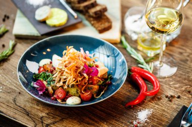 Tavuklu sıcak salata. Badem patatesi, mini romaine marulu, havuç, vişneli domates, pesto, siyah kök cipsi, karamelli ceviz, pancar balzamisi. Modern restoranda yemek servisi var..