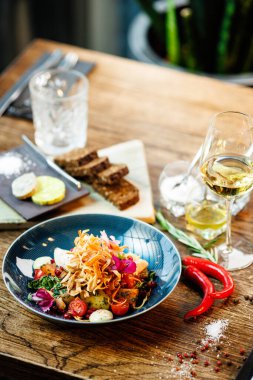 Tavuklu sıcak salata. Badem patatesi, mini romaine marulu, havuç, vişneli domates, pesto, siyah kök cipsi, karamelli ceviz, pancar balzamisi. Modern restoranda yemek servisi var..