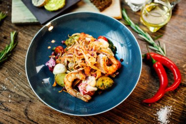 Arjantin kral karidesli sıcak salata. Badem patatesi, mini romaine marulu, havuç, vişneli domates, pesto, siyah kök cipsi, karamelli ceviz, pancar balzamisi. Modern restoranda yemek servisi..