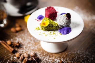 Hurmalardan yapılmış vejetaryen trüf mantarı, bir tepside badem ve fıstık ezmesi. Modern gurme mutfağındaki bir masada öğle yemeği olarak sunulan lezzetli ve sağlıklı yiyecekler..