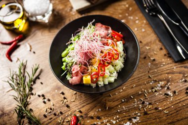 Sığır eti dürtme, cam erişte, avokado, edamame ve mango kasesi. Modern gurme mutfağındaki bir masada öğle yemeği olarak sunulan lezzetli ve sağlıklı yiyecekler..