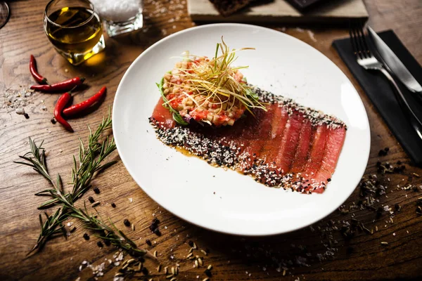 stock image Tuna sashimi with tomato salsa and crispy leek on white plate. Delicious healthy Japan traditional snacks seafood closeup served on a table for lunch in modern gourmet cuisine restaurant.