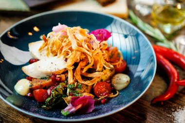 Tavuklu sıcak salata. Badem patatesi, mini romaine marulu, havuç, vişneli domates, pesto, siyah kök cipsi, karamelli ceviz, pancar balzamisi. Modern restoranda yemek servisi var..