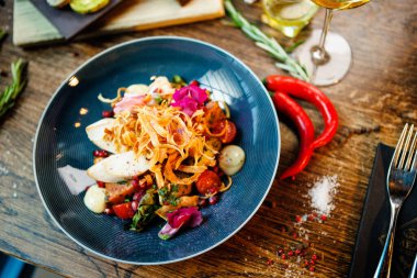 Tavuklu sıcak salata. Badem patatesi, mini romaine marulu, havuç, vişneli domates, pesto, siyah kök cipsi, karamelli ceviz, pancar balzamisi. Modern restoranda yemek servisi var..