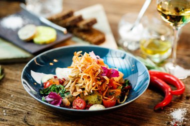 Tavuklu sıcak salata. Badem patatesi, mini romaine marulu, havuç, vişneli domates, pesto, siyah kök cipsi, karamelli ceviz, pancar balzamisi. Modern restoranda yemek servisi var..