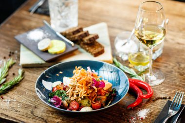 Tavuklu sıcak salata. Badem patatesi, mini romaine marulu, havuç, vişneli domates, pesto, siyah kök cipsi, karamelli ceviz, pancar balzamisi. Modern restoranda yemek servisi var..