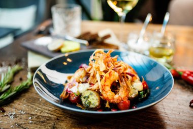 Arjantin kral karidesli sıcak salata. Badem patatesi, mini romaine marulu, havuç, vişneli domates, pesto, siyah kök cipsi, karamelli ceviz, pancar balzamisi. Modern restoranda yemek servisi..