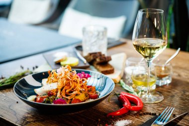 Tavuklu sıcak salata. Badem patatesi, mini romaine marulu, havuç, vişneli domates, pesto, siyah kök cipsi, karamelli ceviz, pancar balzamisi. Modern restoranda yemek servisi var..