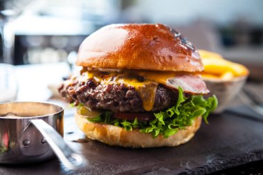 Chicken burger with avocado and 2 cheeses. Delicious healthy traditional food closeup served for lunch in modern gourmet cuisine restaurant.