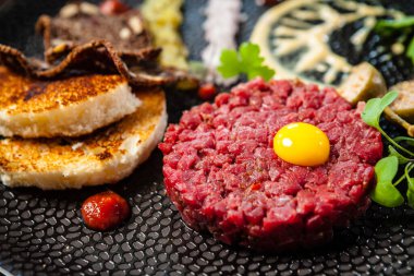 Black Angus 'tan sığır etli tartar. Soğan, bıldırcın yumurtası, domates sosu, hardal mayonezi. Lezzetli sağlıklı İtalyan geleneksel yemekleri modern gurme mutfağında öğle yemeği için servis edilir..