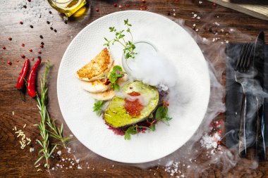 Ton balıklı tartar. Alabalık yumurtası, avokado kremi, marine edilmiş soğan. Lezzetli sağlıklı İtalyan geleneksel yemekleri modern gurme mutfağında öğle yemeği için servis edilir..