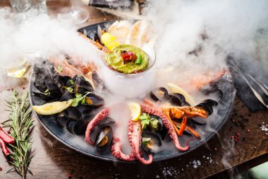 2-4 kişi için deniz ürünleri tabağı. Istakoz, ahtapot, mavi midye, Arjantin kral karidesi, ton balığı. Modern gurme yemek restoranında öğle yemeği olarak sunulan lezzetli, sağlıklı geleneksel yemekler..