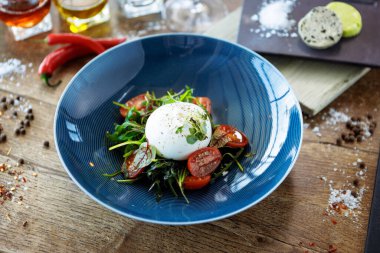 Paprika-mantar reçelli burrata ve vişneli domates salatası. Lezzetli sağlıklı İtalyan geleneksel yemekleri modern gurme mutfağında öğle yemeği için servis edilir..