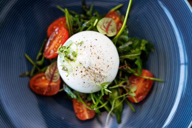 Paprika-mantar reçelli burrata ve vişneli domates salatası. Lezzetli sağlıklı İtalyan geleneksel yemekleri modern gurme mutfağında öğle yemeği için servis edilir..