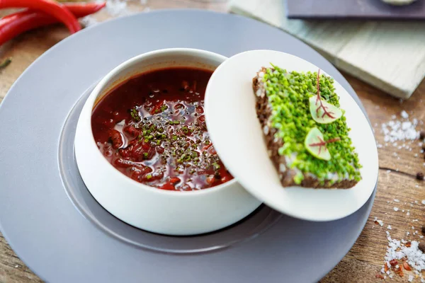 罗宋汤 黑安格斯牛肉 酸奶油 烤面包 在碗中夹杂着石灰 美味的健康食品特写在现代美食餐厅的桌子上吃午饭 图库照片