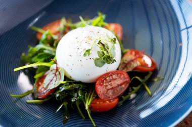 Paprika-mantar reçelli burrata ve vişneli domates salatası. Lezzetli sağlıklı İtalyan geleneksel yemekleri modern gurme mutfağında öğle yemeği için servis edilir..