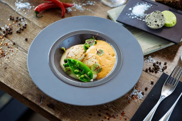 用虾泡 花椰菜奶油和青豆泡在盘子里 美味的健康海鲜特写在现代美食餐厅的桌子上吃午饭 图库照片