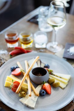 İki kişilik peynir tabağı: keçi peyniri kreması, gorgonzola, camembert, grissini ve incir reçeli. Lezzetli sağlıklı İtalyan geleneksel yemekleri modern gurme mutfağında öğle yemeği için servis edilir..