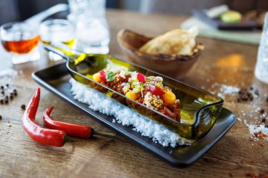 Black Angus 'tan sığır etli tartar. Yumurta sarısı, salatalık turşusu, soğan soğanı, kişniş ve hardal çekirdeği. Modern gurme lokantasında öğle yemeğinde lezzetli ve sağlıklı İtalyan yemekleri servis ediliyor..