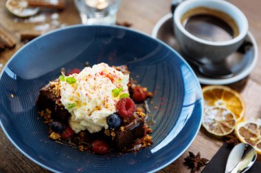 Tuzlu karamelli kek. Anglaise köpüğü, ahududu sosu, ceviz ve taze böğürtlen. Modern gurme yemek restoranında öğle yemeği olarak sunulan lezzetli tatlı tatlı yemekleri..