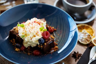 Tuzlu karamelli kek. Anglaise köpüğü, ahududu sosu, ceviz ve taze böğürtlen. Modern gurme yemek restoranında öğle yemeği olarak sunulan lezzetli tatlı tatlı yemekleri..