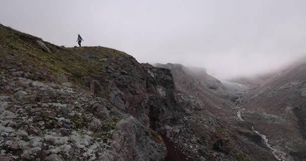 カザス山脈のトレッキングコースで一人でハイキングする女性 グレージェティ氷河ステップナントミンダ ジョージア カザベックピーク近く — ストック動画