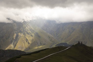 Gürcistan Kafkasya 'daki Kazbek Dağı' ndaki Gergeti Üçlü Hıristiyan Kilisesi bulutlu bir günde