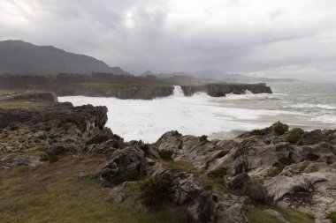 Bufones de Pria, Asturias sahillerinde bulutlu bir günde dalgalı denizlerde ve kıyılarda sprey ile