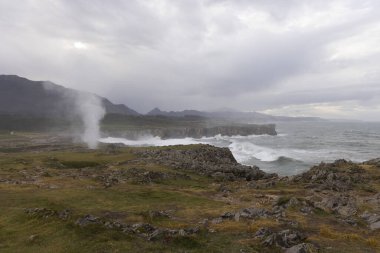 Asturias kıyıları Bufones de Pria 'da bulutlu bir günde dalgalar ve dalgalar kayalık kıyılara vuruyor.