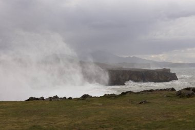 Bufones de Pria, Asturias sahillerinde bulutlu bir günde dalgalı denizlerde ve kıyılarda sprey ile
