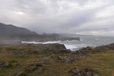 Asturias kıyıları Bufones de Pria 'da bulutlu bir günde dalgalar ve dalgalar kayalık kıyılara vuruyor.