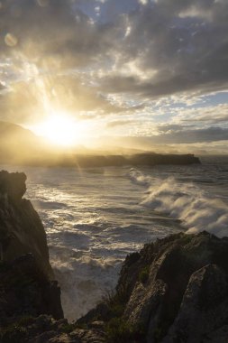 Camino de Santiago ocean Atlantic path in Northern Asturias seaside landscape with huge waves on a sunny bright day clipart