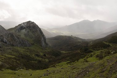 Astuarias 'taki Las Ubinas la Mesa doğal parkının bulutlu manzarası dramatik bulutlar ve güneşli panoramik çayırlar, orman ve tepeler