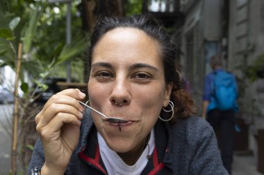 Genç İspanyol kadının portresi. Dışarıda tek başına kahve içiyor. Gülümsüyor. 