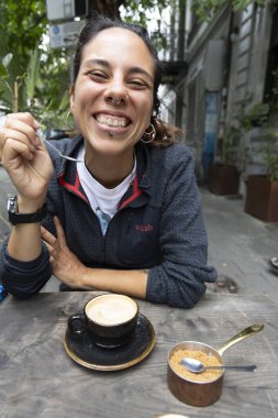 Genç İspanyol kadının portresi. Dışarıda tek başına kahve içiyor. Gülümsüyor. 