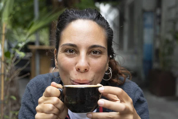 Genç İspanyol kadının portresi. Dışarıda tek başına kahve içiyor. Gülümsüyor. 