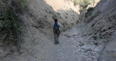 Gürcistan 'daki Vashlovani Milli Parkı' nda dik uçurumların olduğu vadide yürüyüş yapan genç bir kadın. 