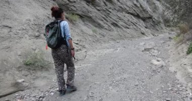 Gürcistan 'daki Vashlovani Milli Parkı' nda dik uçurumların olduğu vadide yürüyüş yapan genç bir kadın. 