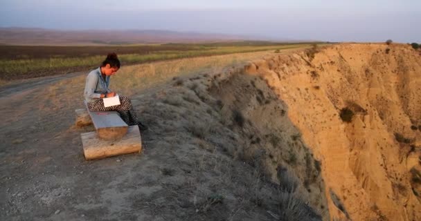 Młoda Kobieta Siedząca Ławce Nad Wzgórzami Pisząca Notatniku Parku Narodowym — Wideo stockowe