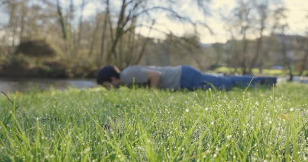 Молодой Человек Отжимается Парке Зеленой Траве Солнечным Боке — стоковое видео