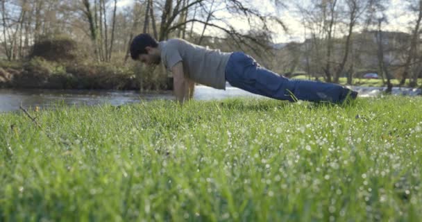 Joven Flaco Haciendo Flexiones Parque Junto Río Hierba Verde Con — Vídeos de Stock