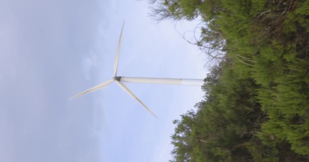 明確な青空の背景に回転する風車タービンの垂直ビデオ 電気を生成する — ストック動画