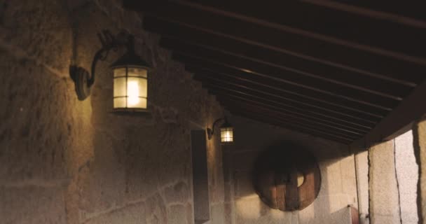 日落时用明灯挂在墙上的旧房子外墙石质阳台 — 图库视频影像