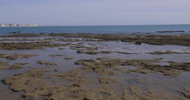 Cadiz şehir binalarının panoramik manzarası güneşli bir günde mavi gökyüzü ile okyanusun yanındaki cephede.