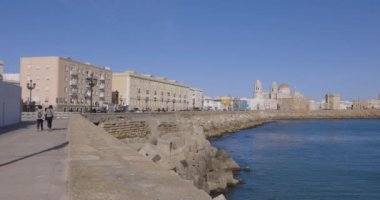 Açık gökyüzü şehri panoramik tepsisiyle güneşli bir günde mavi suyun yanında binaları ve okyanusları olan Cadiz şehri.