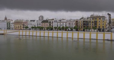 Kara bulutların olduğu bulutlu bir günde Sevilla İspanya 'nın nehir manzarası ve dış tarafı inşa ediliyor.