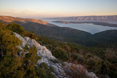 Çarpıcı bir yamaç manzarası yemyeşil, doğa ile topoğrafik özellikler arasındaki uyumu altın saat ışığı altında gösteren geniş bir manzarayı gözler önüne serer..