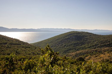 Kibar dalgaların çakıllı bir sahile vuruşunun resimsel bir sahnesi. 